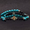 Stack of turquoise and black beaded bracelets on a dark background